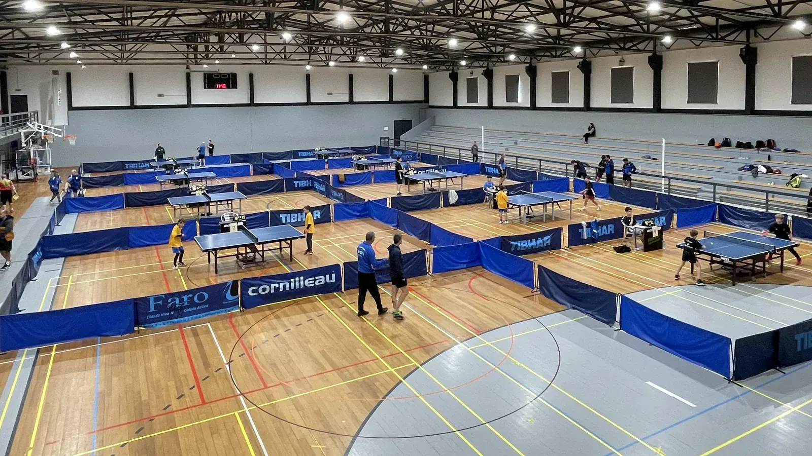 O interior do Pavilhão Desportivo de Paderne, visto da bancada, durante um torneio de ténis de mesa